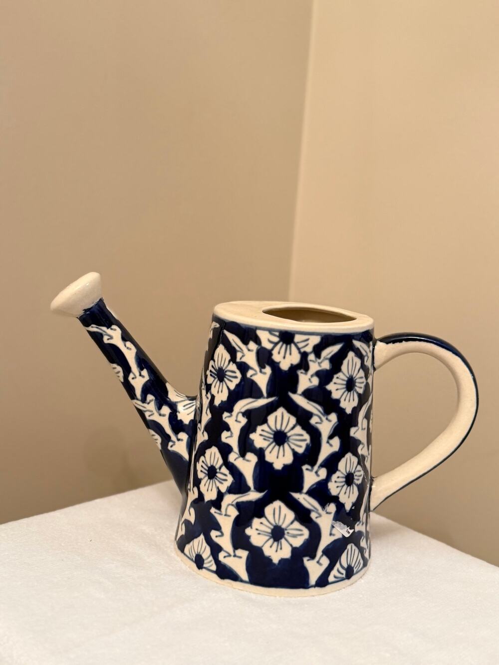 Pottery ceramic watering can features a intricate, hand-painted floral pattern